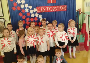 Dzieci na tle dekoracji z okazji Narodowego Święta Niepodległości.